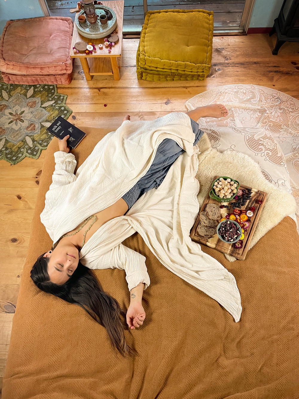 Woman lays on bed in gauze robe