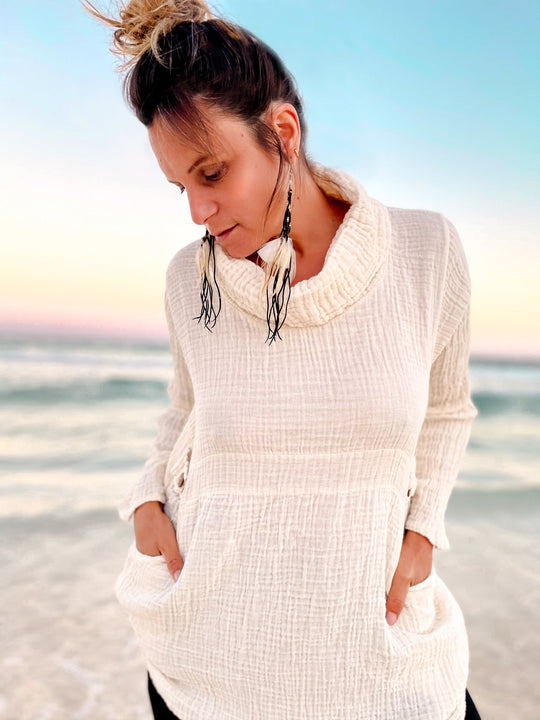 Woman shows off undyed cowl neck shirt with long sleeves.